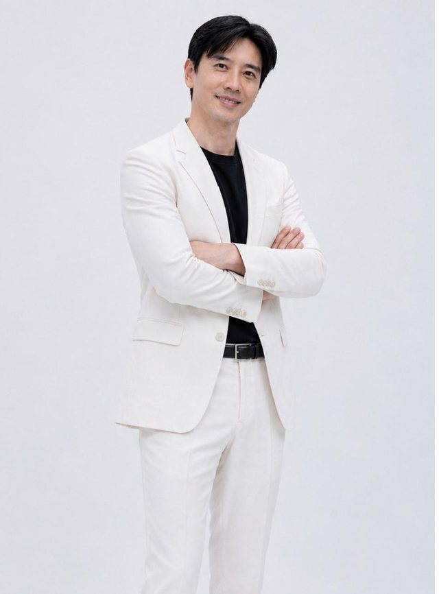 Dato' Seri Ivan Teh in a white suit with arms folded against a pale grey studio backdrop
